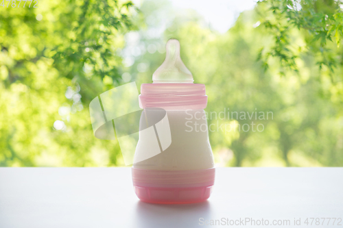 Image of infant milk formula in baby bottle on table