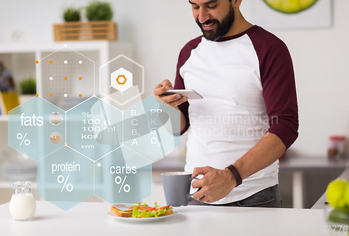 Image of man with phone and food nutritional value chart