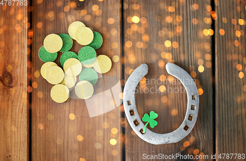 Image of horseshoe with shamrock on wooden background