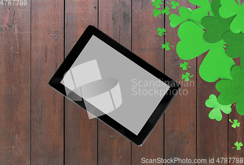 Image of tablet pc and st patricks day decorations on wood