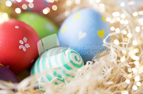 Image of close up of colored easter eggs in straw