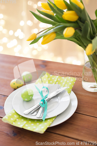 Image of easter egg, plates, cutlery and tulip flowers