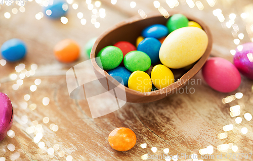 Image of chocolate easter egg and candy drops on table