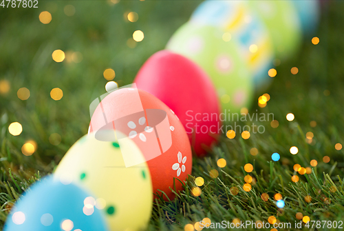 Image of row of colored easter eggs on artificial grass