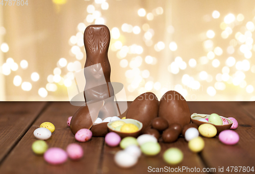 Image of chocolate eggs, easter bunny and candies on wood