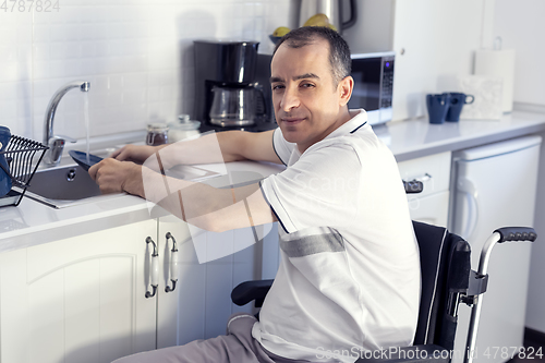 Image of Young man Disabled Man On Wheelchair Washing Dishes