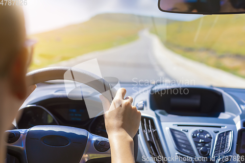 Image of Girl hands on the steering wheel of a car while driving