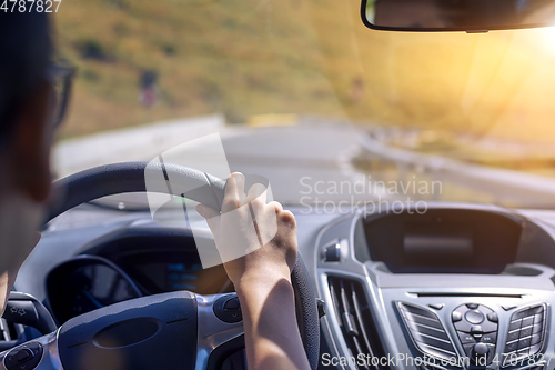 Image of Girl hands on the steering wheel of a car while driving