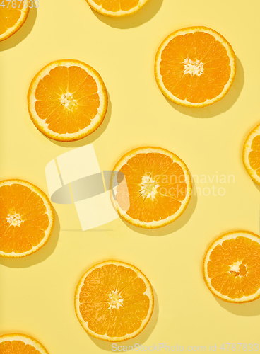 Image of fresh orange slices on yellow background