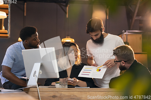 Image of Colleagues working together in modern office using devices and gadgets during creative meeting