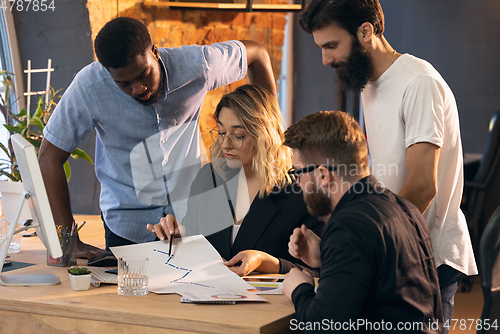 Image of Colleagues working together in modern office using devices and gadgets during creative meeting