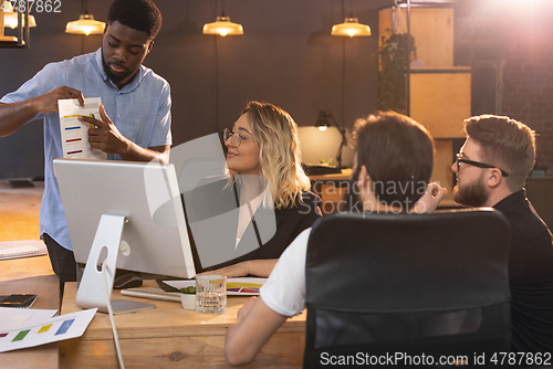 Image of Colleagues working together in modern office using devices and gadgets during creative meeting