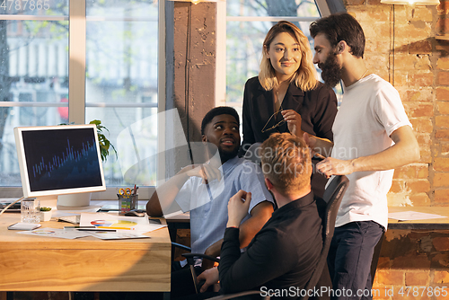 Image of Colleagues working together in modern office using devices and gadgets during creative meeting