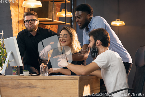 Image of Colleagues working together in modern office using devices and gadgets during creative meeting