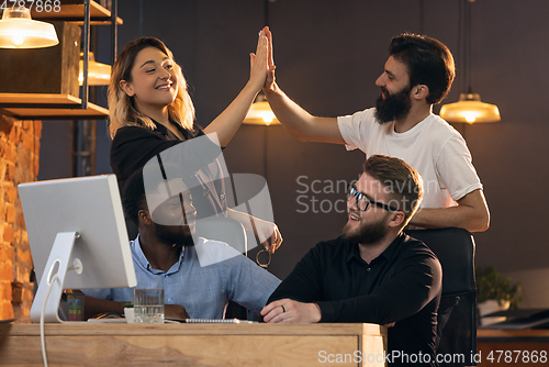 Image of Colleagues working together in modern office using devices and gadgets during creative meeting