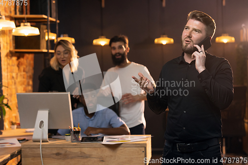 Image of Colleagues working together in modern office using devices and gadgets during creative meeting