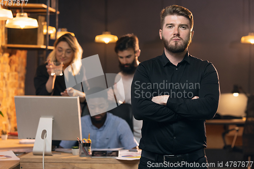 Image of Colleagues working together in modern office using devices and gadgets during creative meeting