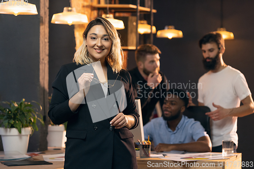 Image of Colleagues working together in modern office using devices and gadgets during creative meeting