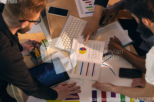 Image of Colleagues working together in modern office using devices and gadgets during creative meeting