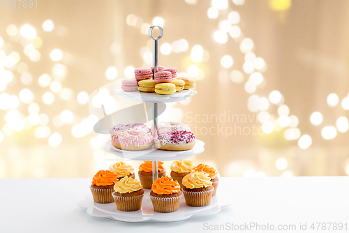 Image of glazed donuts, cupcakes and macarons on stand