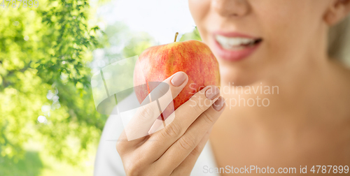 Image of close up of woman holding ripe red apple