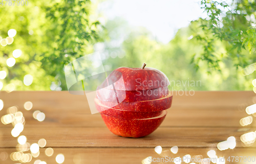 Image of sliced red apple on wooden table