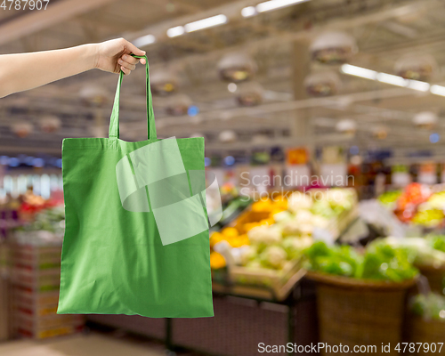 Image of hand holding reusable canvas bag for food shopping