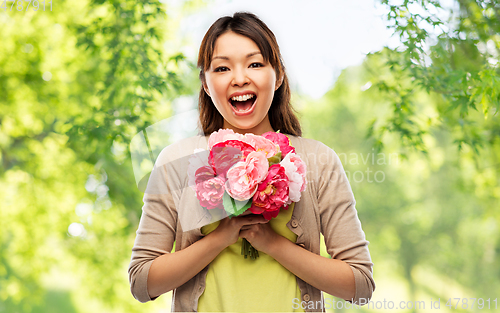 Image of happy laughing asian woman with bunch of flowers