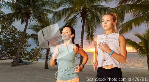 Image of women or female friends with earphones running