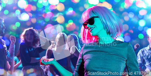 Image of woman in wig and sunglasses dancing at nightclub