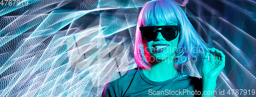 Image of happy woman in wig and sunglasses over neon lights