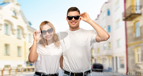 Image of happy couple in t-shirts and sunglasses in city