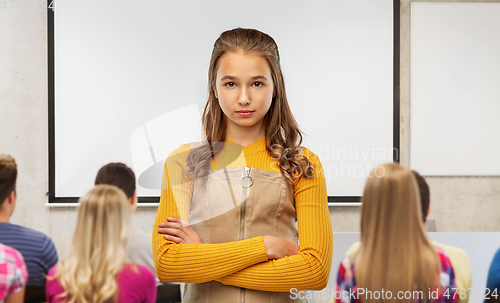 Image of serious student girl with crossed arms at school