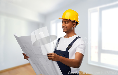 Image of happy indian builder in helmet with blueprint