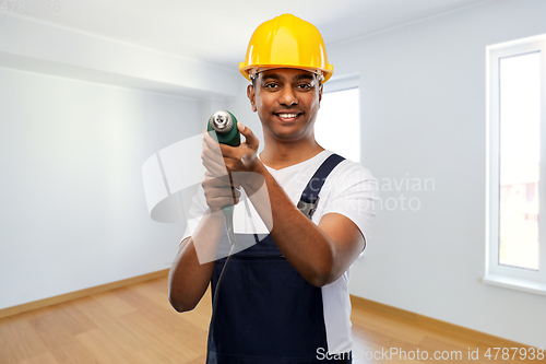 Image of happy indian builder in helmet with electric drill