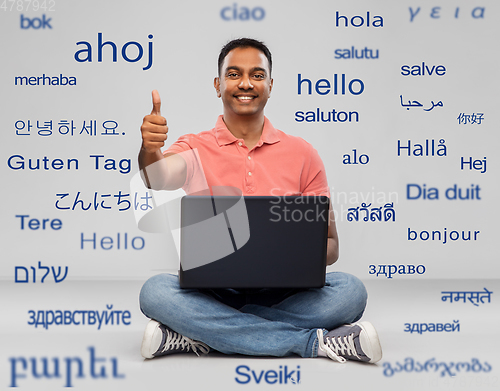 Image of happy indian man with laptop showing thumbs up