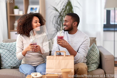 Image of happy couple with takeaway food and drinks at home