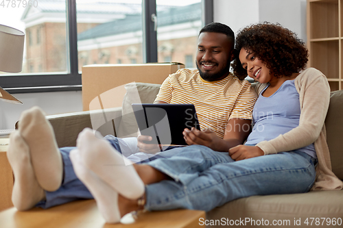 Image of happy couple with tablet pc computer at new home