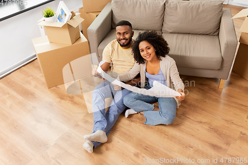 Image of couple with boxes and blueprint moving to new home