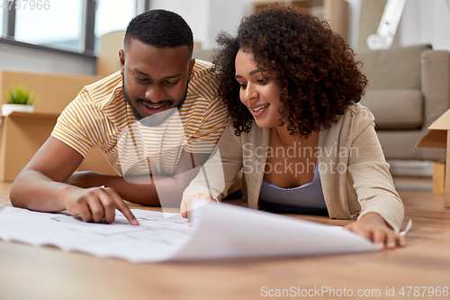 Image of couple with boxes and blueprint moving to new home