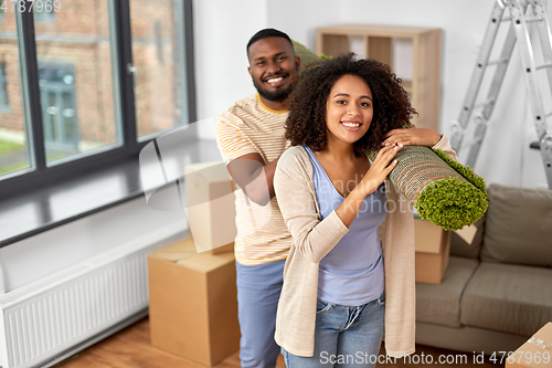 Image of happy couple with carpet moving to new home