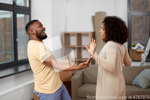 Image of happy couple moving to new home and dancing