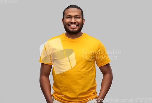 Image of smiling african american man in yellow t-shirt
