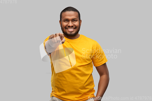 Image of smiling african american man pointing to camera