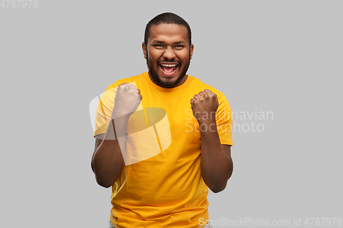 Image of smiling african american man celebrating success