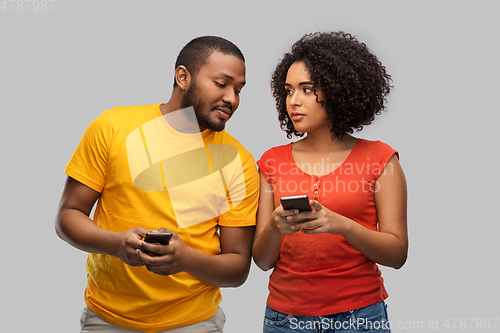 Image of happy african american couple with smartphones