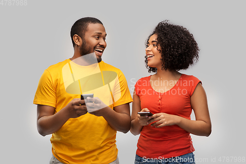 Image of happy african american couple with smartphones