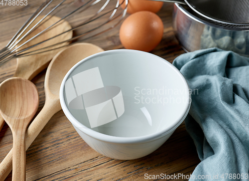 Image of empty white bowl on wooden table