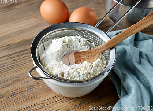 Image of bowl and flour strainer on kitchen table