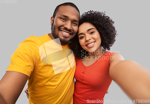 Image of happy african american couple taking selfie